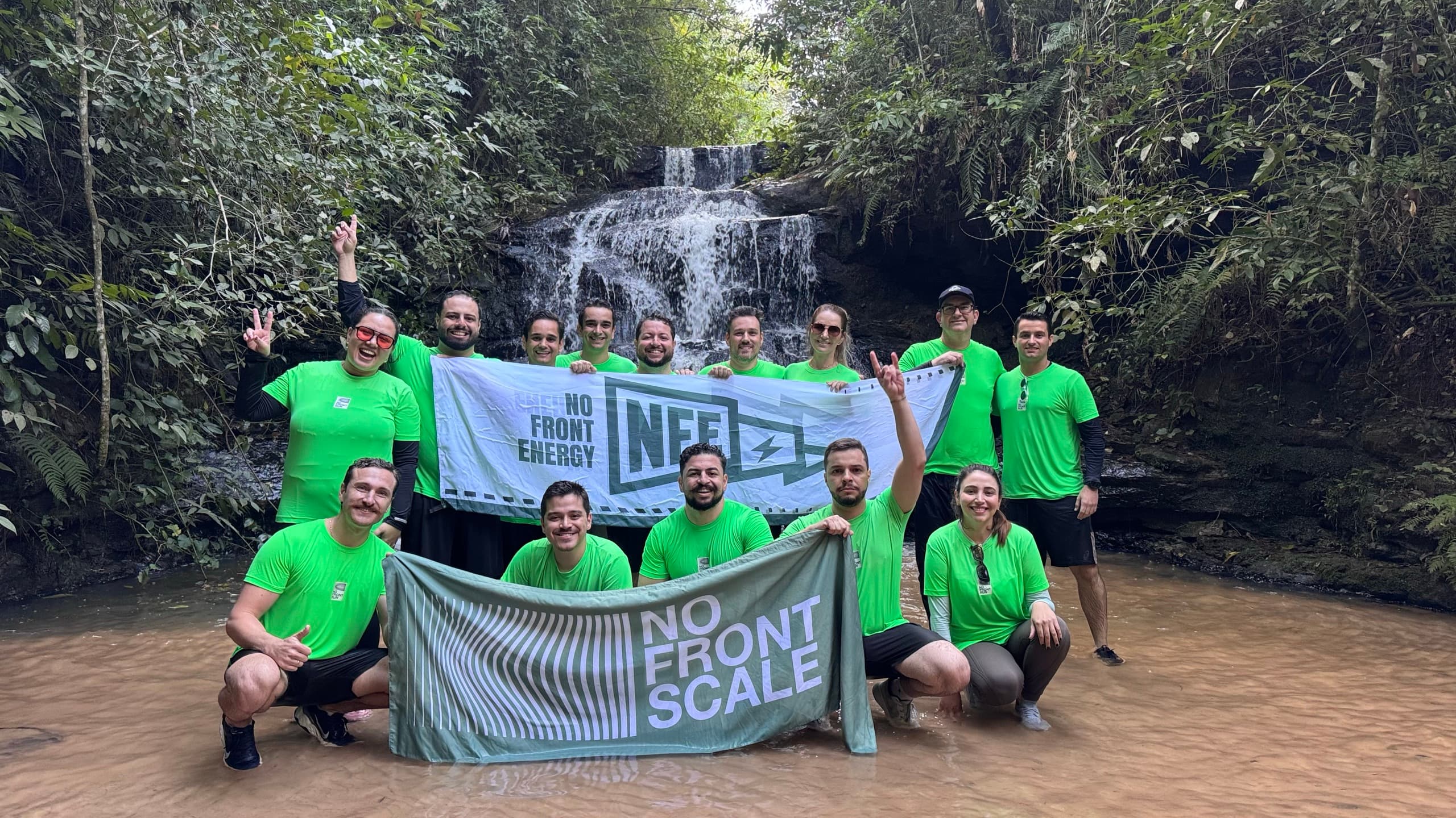 Participantes do No Front Energy reunidos diante de uma cachoeira